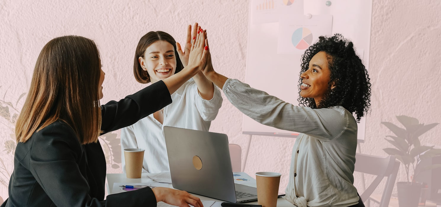 Team high-fiving around laptop
