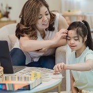 Woman caressing her daughter while she plays